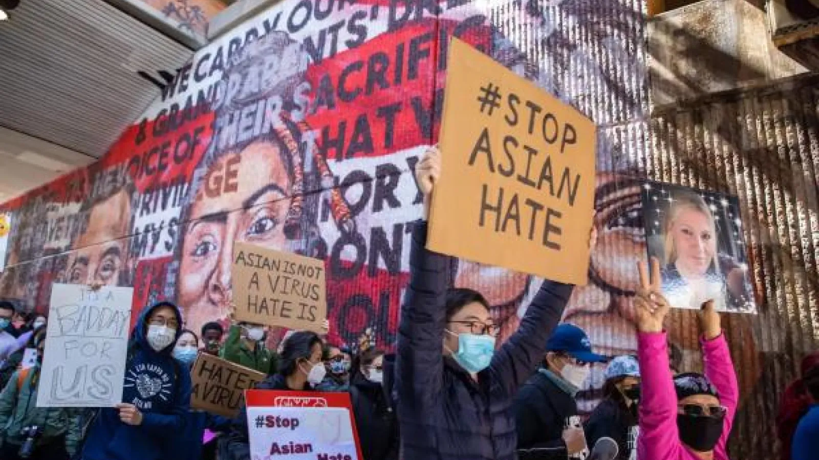 People at a small protest with signs that say stop Asian hate